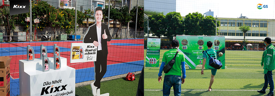 A Kixx promotional stand positioned next to a Kixx Nguyen Quang Hai standee and Grab Cup attendees test their skills by kicking footballs at targets for a chance to win Kixx products.