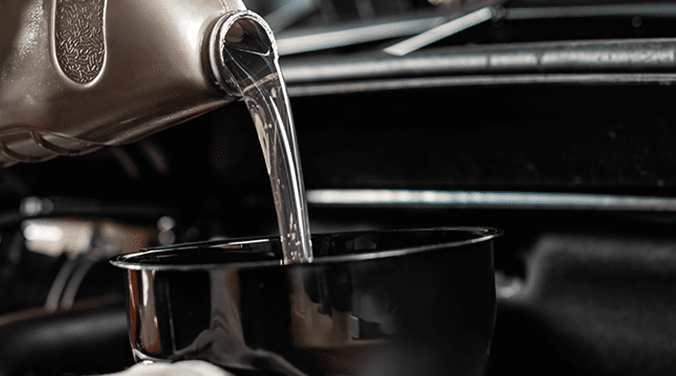 Flushing oil being poured into a car’s oil system