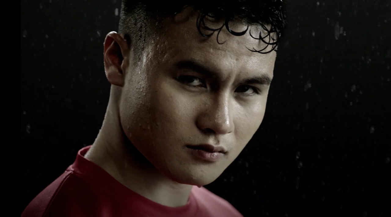 Image 3 | Kixx Newsroom A close-up of Vietnamese football player Nguyen Quang Ha as he looks into the camera against a black background.