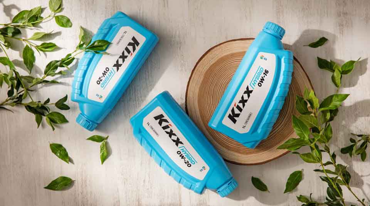 Image 2 | Kixx Newsroom Kixx HYBRID engine oil on top of a wooden stump with green foliage