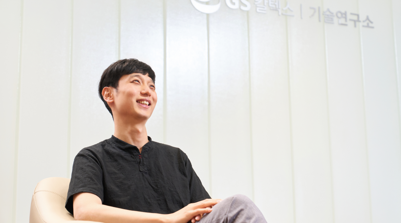 Image 4 | Kixx Newsroom A smiling Rae Wook Cho sits in front of GS Caltex R&D Center signage and looks off-camera