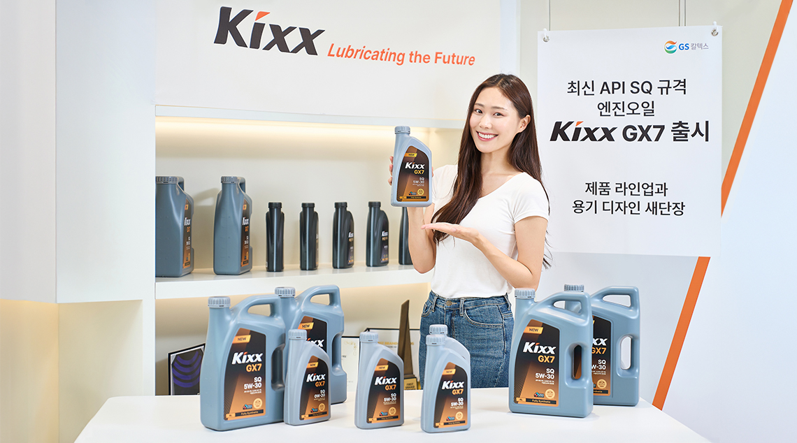 Image 4 | Kixx Newsroom 모델이 Kixx GX7 엔진오일 제품을 소개하고 있는 이미지로, 모델 앞에는 다양한 용량의 제품들이 진열되어있으며 배경에는 브랜드 리뉴얼 및 신제품 출시 소식을 홍보하는 배너가 있음